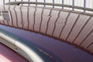 Hail Damage on Maroon SUV roof